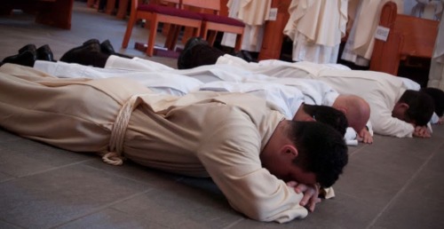 sacerdote rezando en el suelo