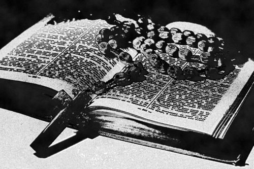 rosario arriba de una biblia