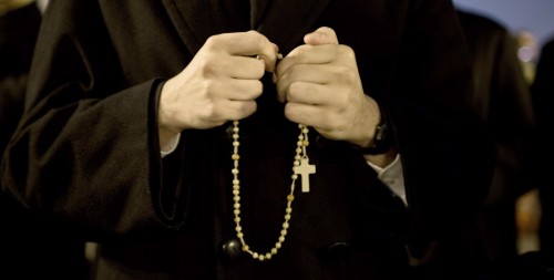 sacerdote con rosario fondo