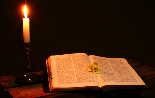 bible book by candle light