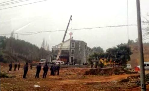 autoridades chinas quitando una criz de una iglesia