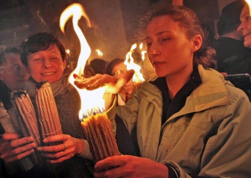 mujeres encendiendo velas con fuego santo