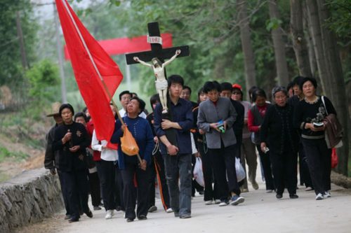 chinos en procesion con cruz de cristo