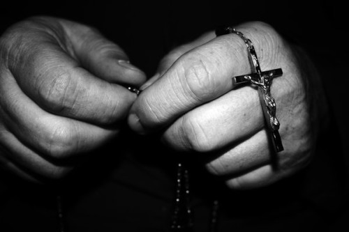 manos con rosario