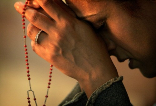 mujer orando rosario