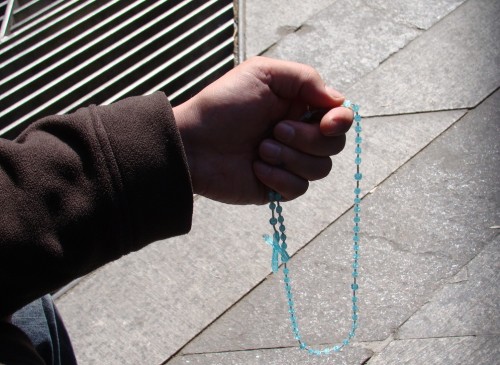 orando con un rosario