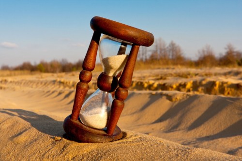 reloj de arena sobre arena fondo