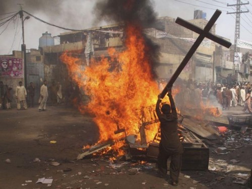 musulman destruyendo una cruz