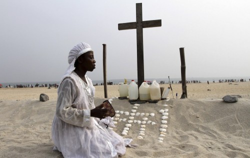 mujer nigeriana ante cruz cristiana